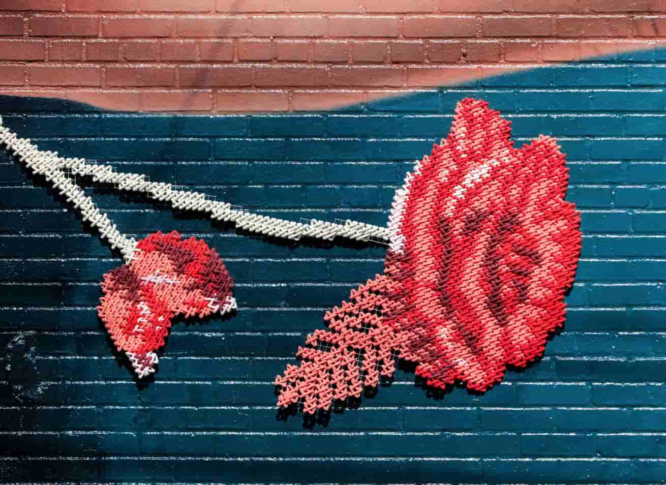 Audible Pride & Prejudice — detail of red embroidered roses on teal wall