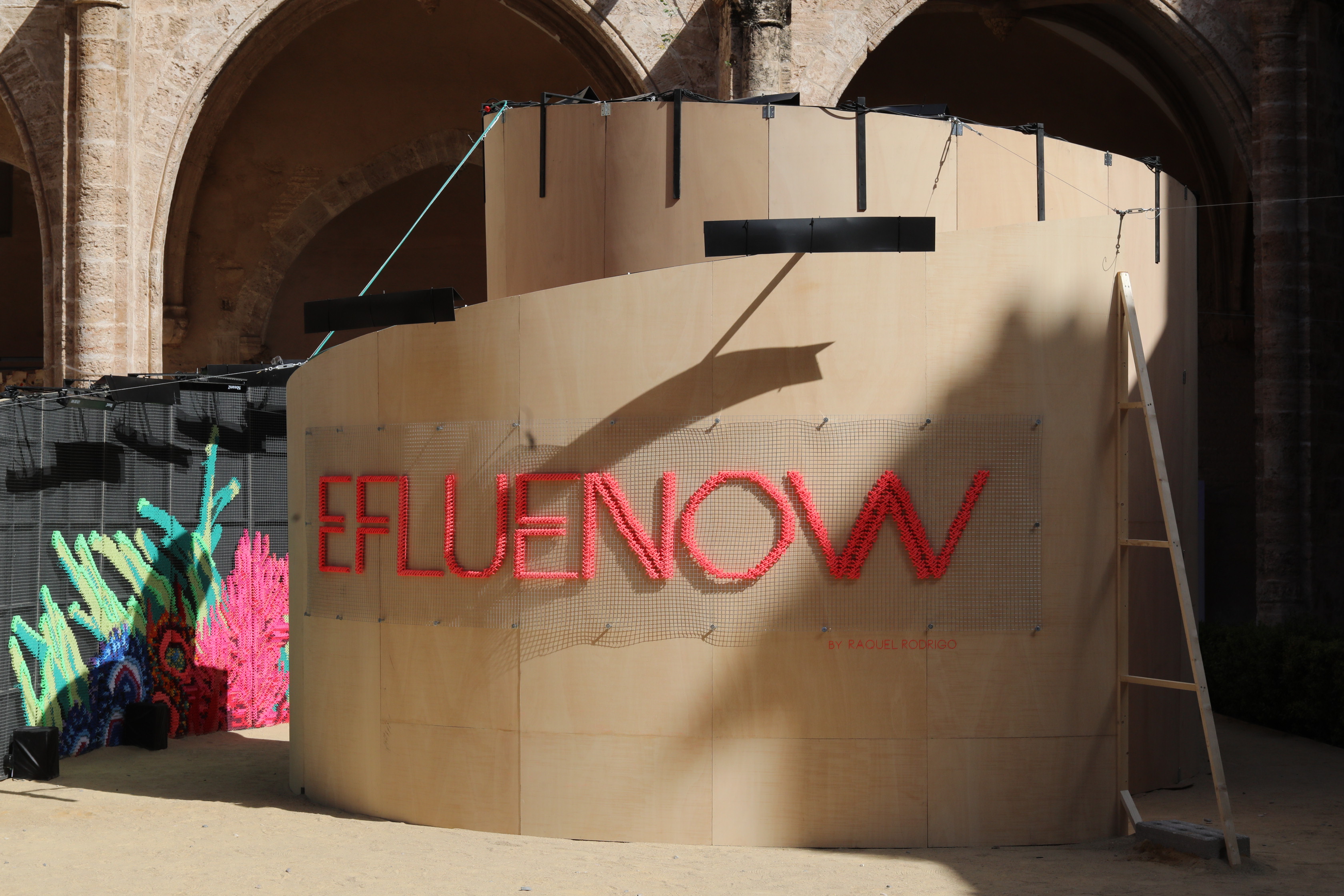 Efluenow — exterior view of the installation title by day