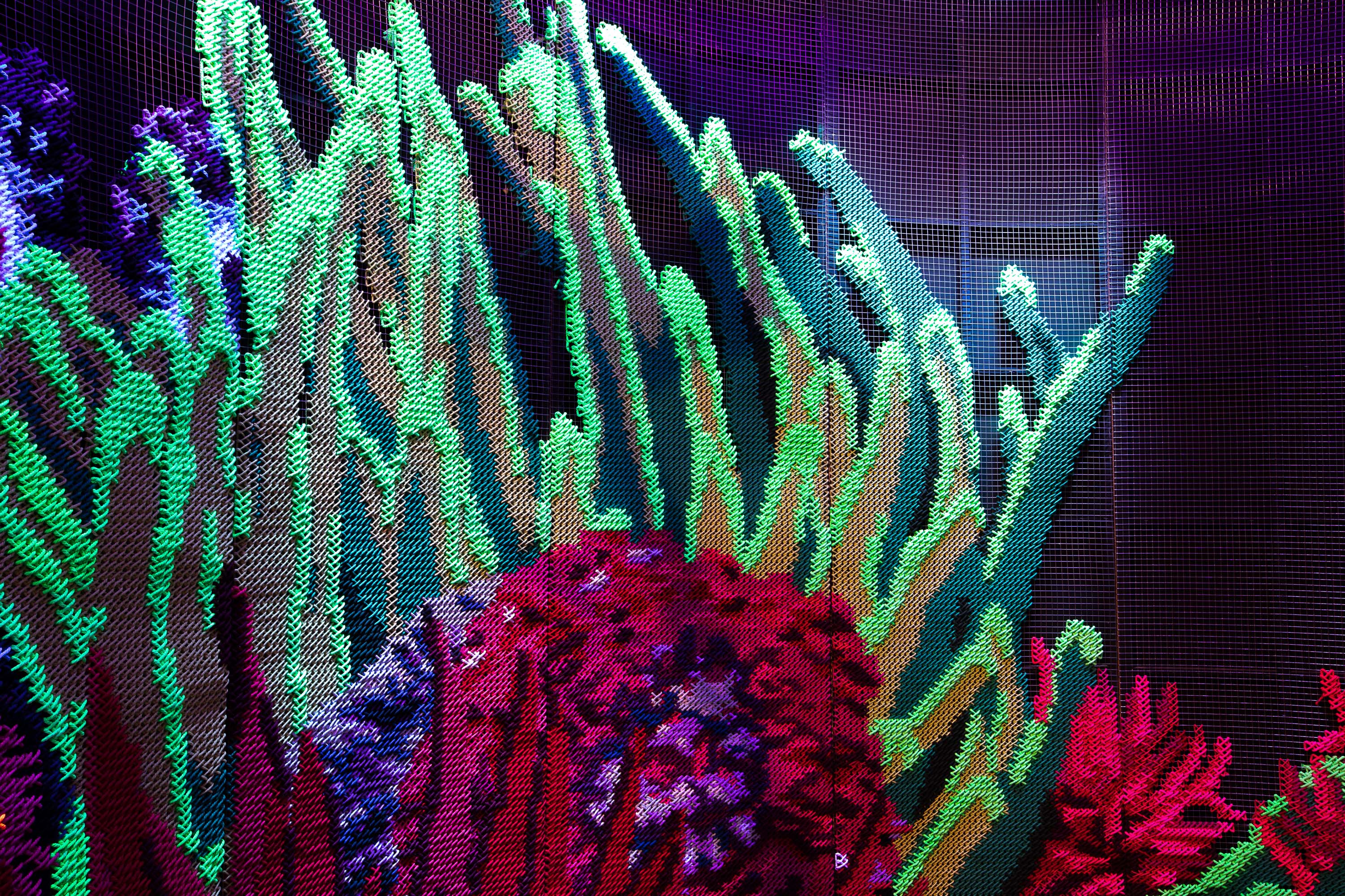 Efluenow — close-up detail of fluorescent embroidery on metallic mesh